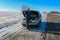 Upset young man calling the car service standing near a broken car at winter road