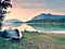 Upside down fishing paddle boat on bank of Alps lake. Morning autumnal lake.