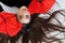 Upside down portrait of beautiful young sexy woman lying on the floor with long wide hair and fashion red paper poppies