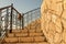 Upstairs steps with metal railings and limestone wall. Limestone texture on the stairs