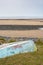 An upturned small boat washed up on the shoreline of a beautiful unspoiled beach