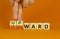 Upward or downward symbol. Businessman turns wooden cubes and changes the word `downward` to `upward`. Beautiful orange table,