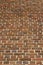 Upward view of a multi hued reddish brown brick wall texture
