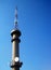 UPWARD VIEW OF A TELECOMMUNICATIONS TOWER AGAINST A BLUE SKY