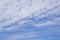 Upward view, wave of softy and white fluffy clouds under deep blue sky