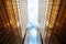 Upwards perspective of symmetrical contemporary skyscrapers, with blue sky and white clouds