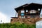 Upwards view of a mountain rescue house on a green meadow with cut logs outside