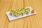 uramaki dragon roll with wasabi and ginseng with avocado slices on top, stuffed with eel and cheese with sesame