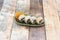 Uramaki salmon sushi roll with seaweed, queso philadelphia and guacamole on green bowl