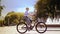 Urban Adventures: Stylish Boy Enjoying a Bike Ride in the City Park, Surrounded by Beautiful Fountain Scenery