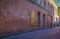 Urban Alley in old city. Old grunge street. Grungy urban background of a brick wall with windows