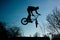 Urban athlete biker performing acrobatic jump. Guy riding bmx bicycle at extreme sport competition. Alternative lifestyle concept