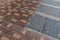 Urban background of sidewalk of mixed brick in red and yellow, inset steel grates