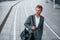 Urban beauty. Young businessman in grey formal wear is outdoors in the city