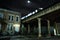 Urban elevated city of Chicago CTA subway train crossing a bridge at night next to a house and a dark alley.