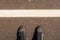 Urban explorer, man in modern shoes standing on asphalt road