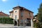 Urban family villa with completely renovated facade and new roof tiles surrounded with surveillance cameras and hedge next to