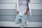 Urban fashionable young man in a stylish white t-shirt in blue ripped jeans in sneakers posing in the city near a modern building