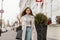 Urban fashionable young woman walks outdoors in the city. Modern brown-haired girl model in stylish outerwear with a trendy