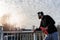 Urban handsome man runner with earphones taking break on the bridge