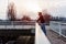 Urban handsome man runner with earphones taking break on the bridge