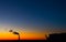 Urban landscape gas boiler pipe with outstanding smoke from burning fuel and silhouettes of city buildings in the colorful sunset