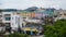 Urban landscape of a residential area at the foot of high mountains and green trees in the foreground on the South Korean island o