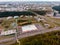 Urban landscape. Storage facilities. Car Parking in contrast to deep green forest, yellowed leaves, grass. Lowering sky.