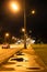 Urban lantern illuminated road after rain in nigh