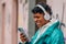 urban latino man with mobile phone and headphones in the street