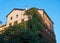 Urban multistory house overgrown with ivy. Ivy covers the walls of the house. Only the upper floors are free from plants