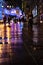 Urban night scene with wet ground reflection with blurry spotlights