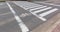 Urban pedestrian crosswalk across an asphalt road in city.