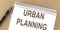 URBAN PLANNING text on a notepad with pen, business