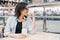 Urban portrait of mature woman wearing glasses with a cup of coffee in shopping entertainment mall, female looking in profile