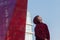 Urban portrait of teenage boy wearing maroon hooded sweatshirt at modern glass skyscraper city background