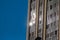 Urban reflections. Sunbeams reflected on glass of a building with blue background