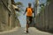 Urban runner workout . Young attractive and athletic black African American man running outdoors on asphalt road training hard