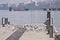 Urban seagulls on a pier with blurred industrial installations o