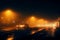 Urban serenity after rain city lights, bridge, car in fog