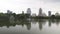 Urban skyline, downtown buildings reflected in the water. Large green Park with a lake on the background of high-rise