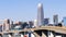 Urban skyline in downtown San Francisco on a sunny day, with clear blue sky; vehicles driving on a raised freeway in the