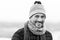 Urban smiling guy. Happy man in woolen hat and scarf. Funny man smiles to camera. Closeup of smiling urban man face