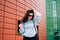 Urban style concept. Close up portrait of fashionable teenage girl in sunglasses posing on city street in summer. Glamour young