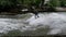 Urban surfers ride the standing wave on the Eisbach River, Munich, Germany. Slow Motion