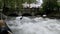 Urban surfers ride the standing wave on the Eisbach River, Munich, Germany. Slow Motion