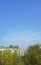 Urban view. Buildings, green trees and blue sky.