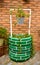 urban water well decorating an urban garden with tires painted, a grey bucket with plants on a brick background