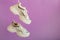 Urban white neon sneakers fly on color purple background with copy space. White sport sneakers shoes levitation. Pair of
