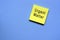 Urgent matter text on yellow sticky note with blue background